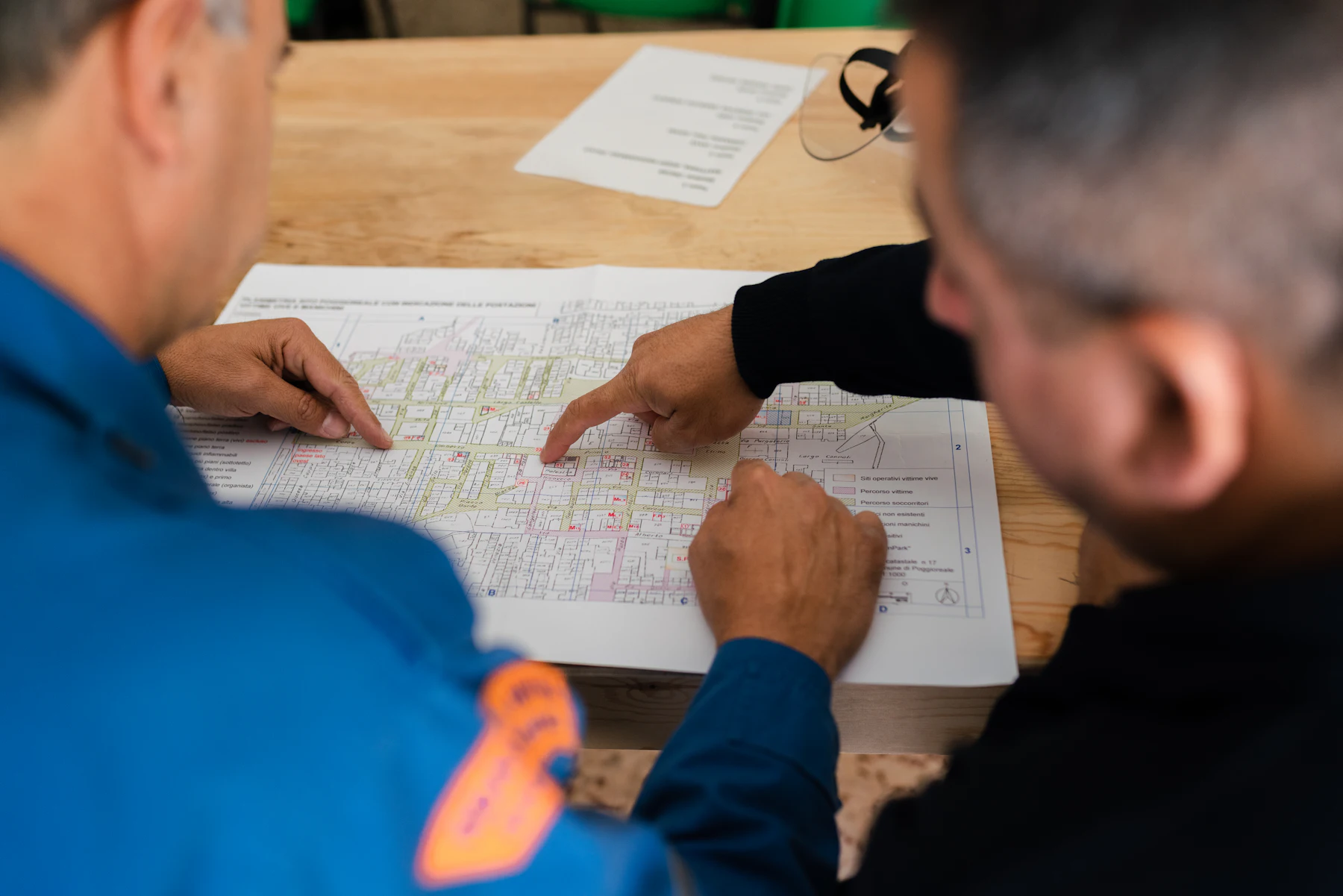 Two professionals reviewing a printed plan together at a work table